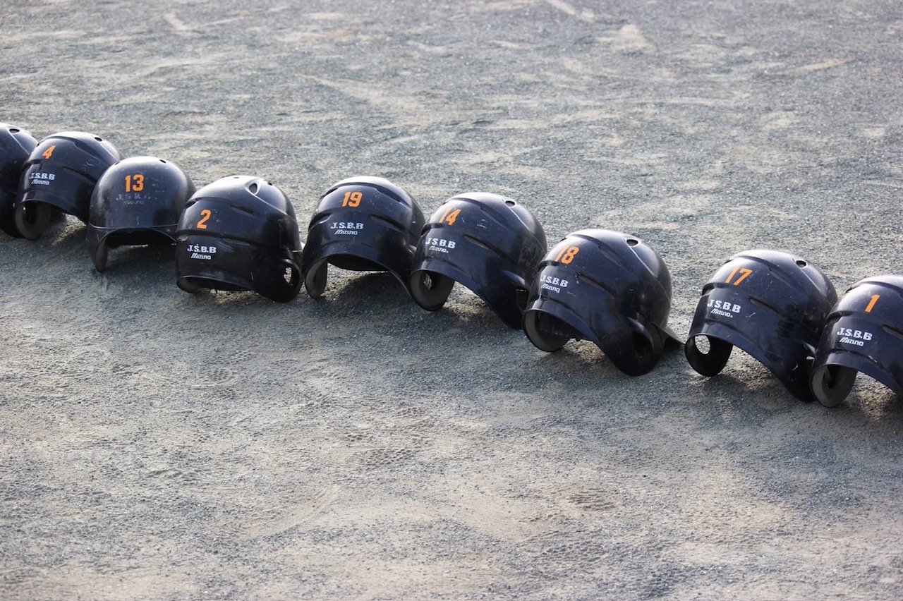 長男の所属する野球チームのヘルメットがグランドに並んでいる画像です。