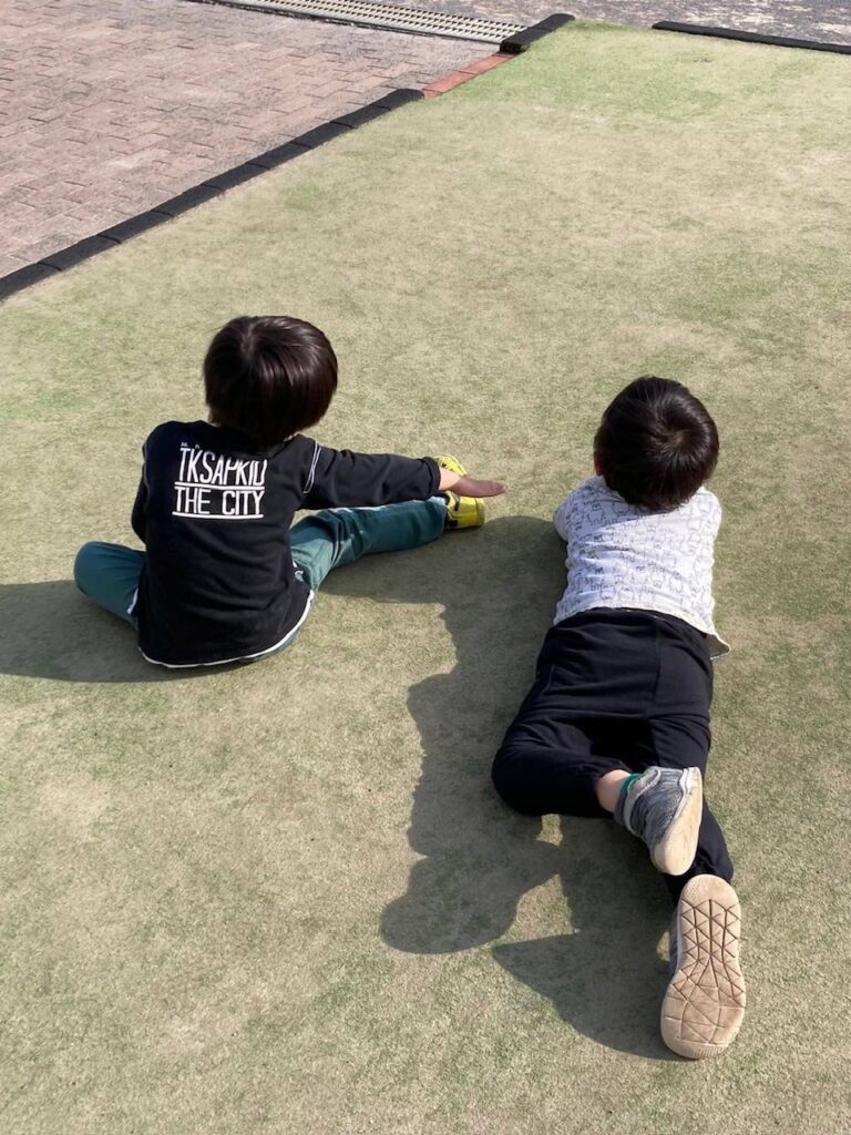 スポ少野球の練習中の兄たちを見つめる弟たち